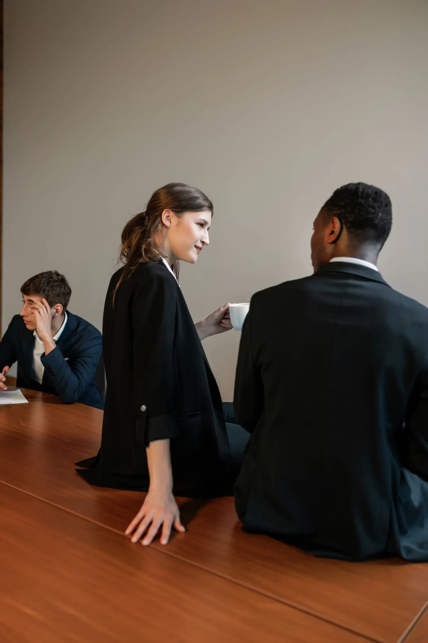Drie collega's in gesprek aan een tafel. Stockfoto, geen opdrachtgever van Arbopartner Brabant.